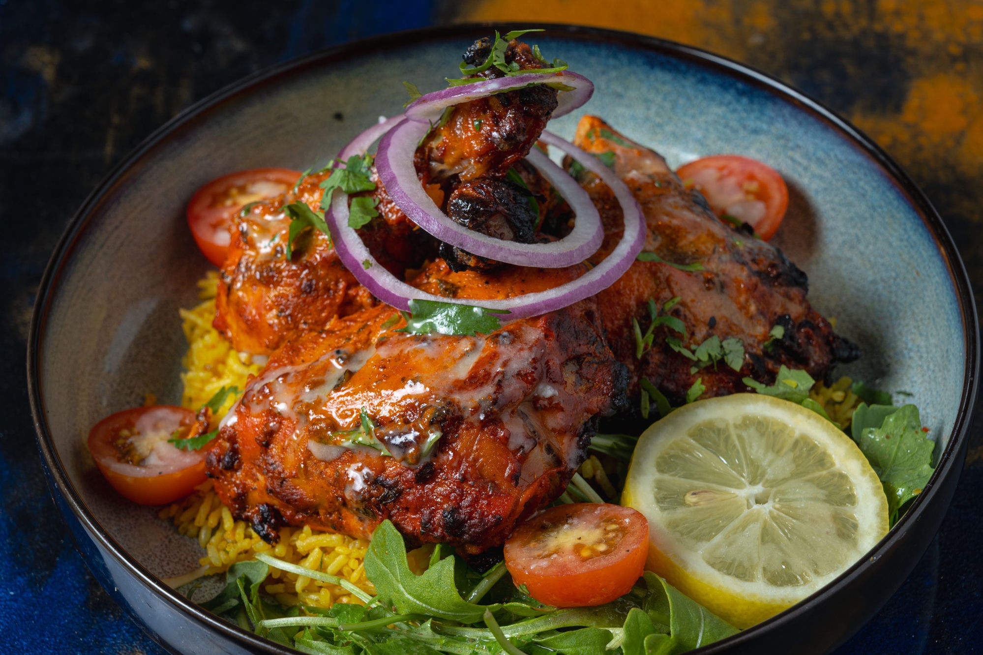 Tandoori chicken with yellow rice and fresh garnishes