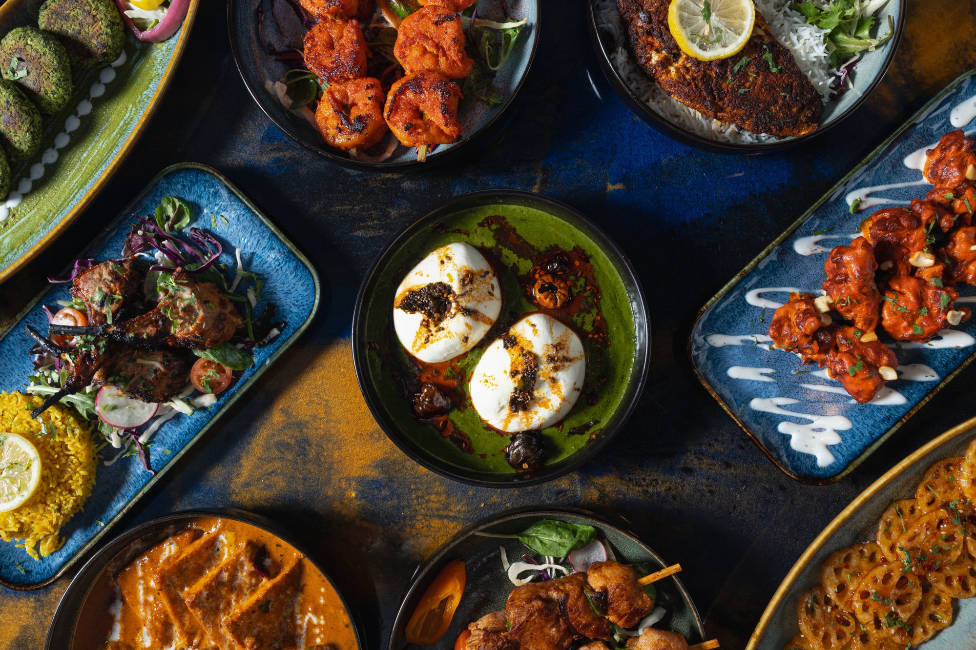Indian and Middle Eastern food spread on blue and gold background