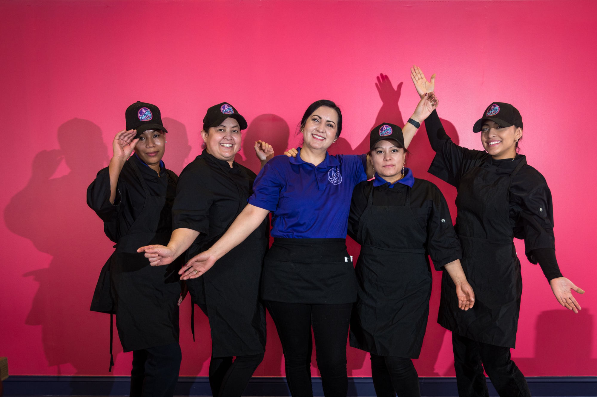 Magos restaurant team on pink wall
